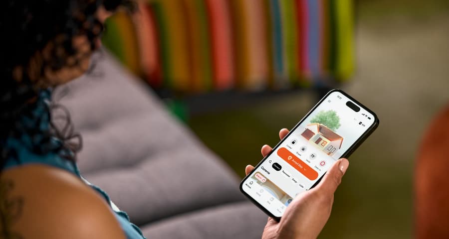 Homeowner using the HomeView feature in the Vivint app to manage security, automation, and energy usage.