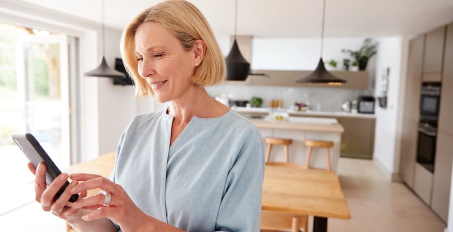 Homeowner with cell phone in a room filled with sunlight